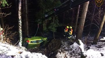 Auto se dvěma osobami skončilo havarované mezi stromy